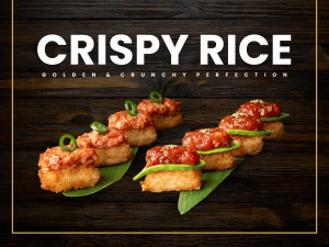 A professional display of Sushi Zanmai Crispy Rice topped with fresh ingredients and served on bamboo leaves.